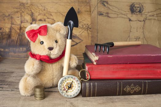 bear toy with shovel old map and compass