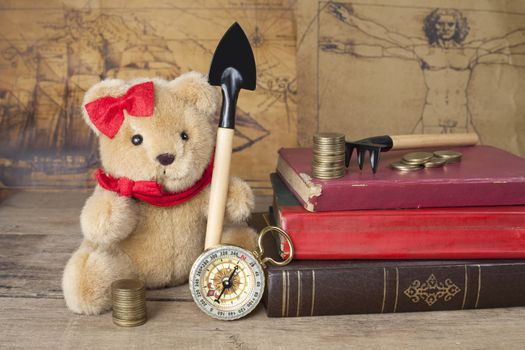 bear toy with shovel old map and compass
