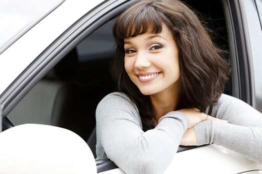 Girl in a car smiling to you.