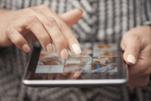 Woman with tablet computer looking digital photos
