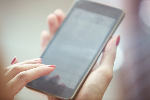 Hands of woman using smartphone