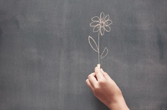 Woman drawing a flower on a blackboard