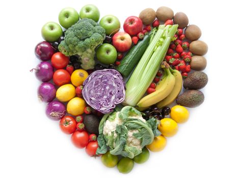 Fruits and vegetables in a heart shape over a white background 