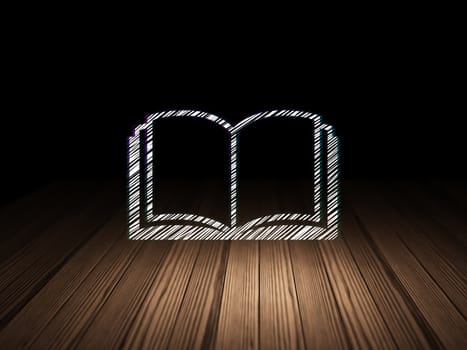 Studying concept: Glowing Book icon in grunge dark room with Wooden Floor, black background
