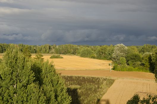 Country farm fields under stormy sky - autumn time landscape