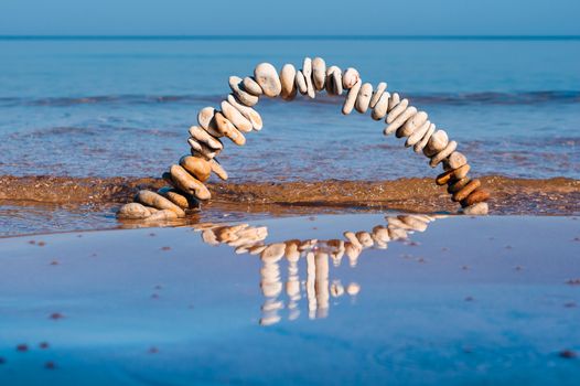 Arch of pebbles on the surface of the sea