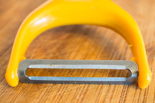 Close up of a sharp peeling knive on wooden background