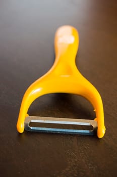 Close up of a sharp peeling knive on wooden background