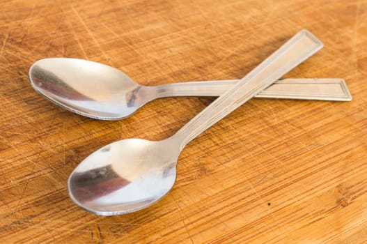 Silver spoons on wooden background