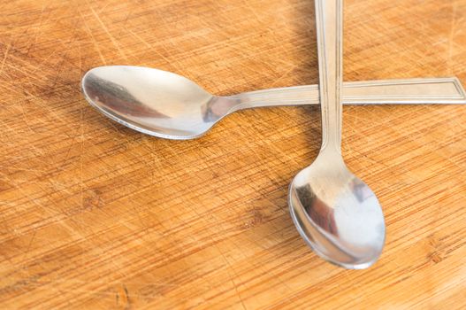 Silver spoons on wooden background