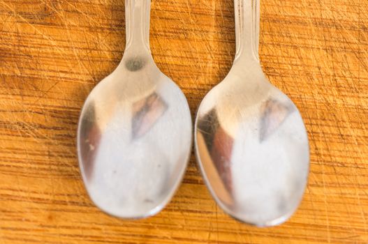 Silver spoons on wooden background