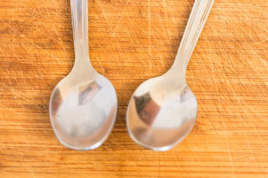 Silver spoons on wooden background