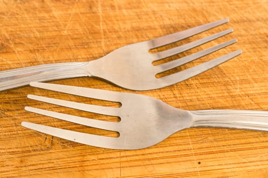 Two silver spoons on wooden background