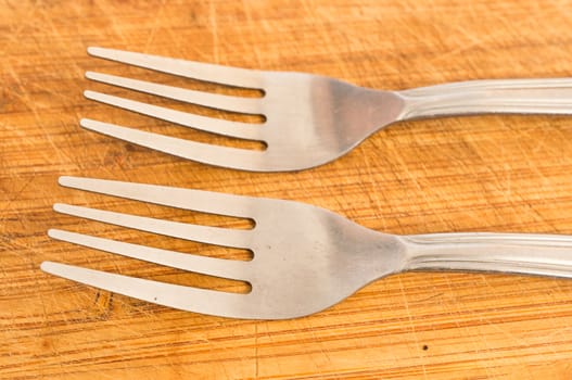 Two silver spoons on wooden background