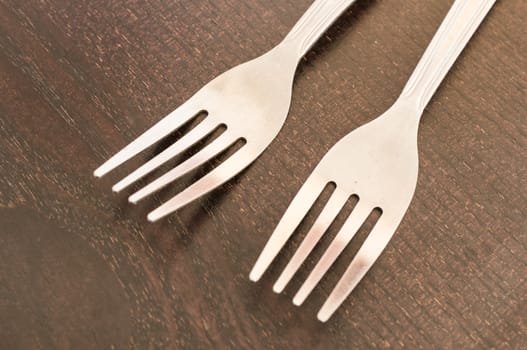 Two silver spoons on wooden background