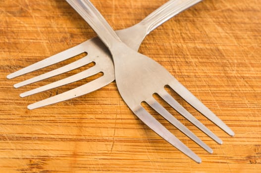 Two silver spoons on wooden background