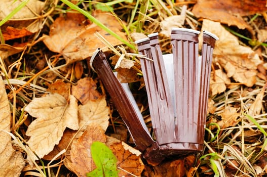 Damaged plastic cup on green grass