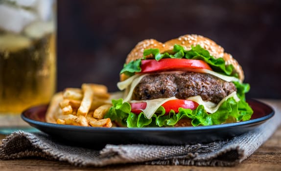 Closeup of Homemade Hamburger with Fresh Vegetables and Drink with Ice in Background