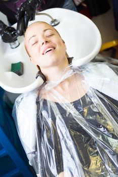 Hairdresser salon. Woman enjoying during hair wash.