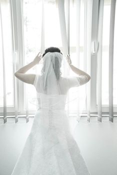 Bride on a window looking for a groom. Wedding concept