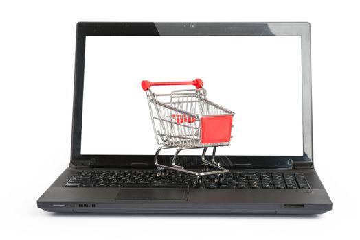 Shopping cart on laptop on isolated white background, close up view