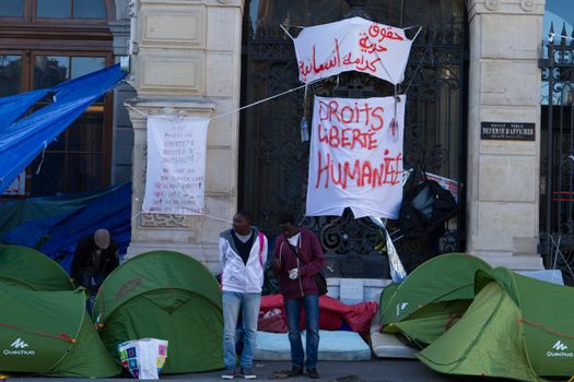FRANCE, Paris: Two refugees stand in front of the city hall of the 18th arrondissement in Paris, on September, 15, 2015. Almost hundred and fifty refugees from South Soudan and Eritrea camp in front of the city hall of the 18th arrondissement in Paris since September, 4, 2015. Paris mayor Anne Hidalgo announced on September, 15, 2015 giving them a place in one of the seven installations opened in the capital and around las week. 