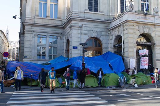 FRANCE, Paris: Around five refugees cross the street near their camp in front of the city hall of the 18th arrondissement in Paris, on September, 15, 2015. Almost hundred and fifty refugees from South Soudan and Eritrea camp in front of the city hall of the 18th arrondissement in Paris since September, 4, 2015. Paris mayor Anne Hidalgo announced on September, 15, 2015 giving them a place in one of the seven installations opened in the capital and around las week. 