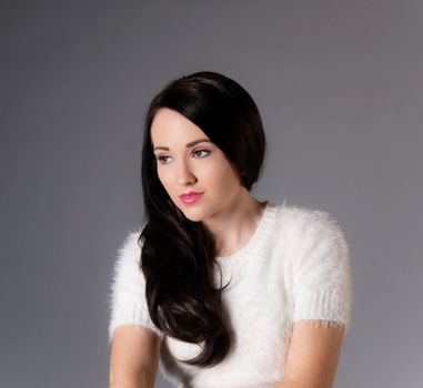portrait of pretty brunette woman in white sweater
