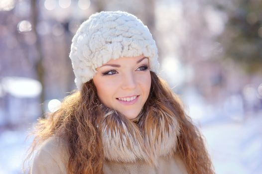 Young woman in white hat in park. Winter