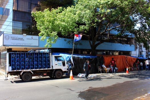 PARAGUAY, Greater Asuncion: 23 bus drivers from the firm Line 49, including one woman, lie crucified in front of the Labor, Employment and Social Security Ministry in Asuncion, on September 14, 2015. 	It has been 76 days since they started to protest after being dismissed by the company. More and more of the protesters have turned to crucifixion during this period to raise awareness of their cause. Some of them have also sewn their lips together on hunger strike. 