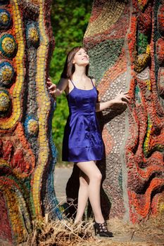 beautiful girl smiling in a blue dress in the summer park