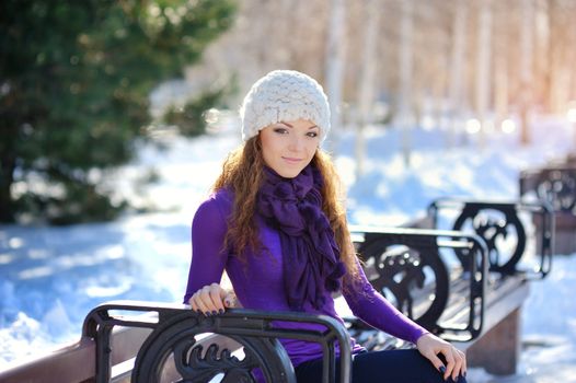 Beautiful and sexy woman sitting on bench in winter