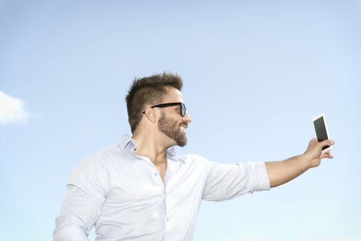 An image of a man taking a selfie with his smart phone