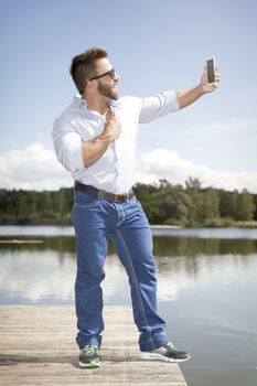 An image of a man taking a selfie with his smart phone