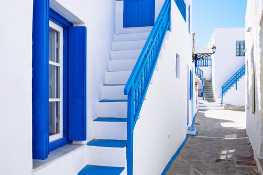 Typical traditional beautiful Greek street in white and blue style, Plaka village on Milos island, Greece