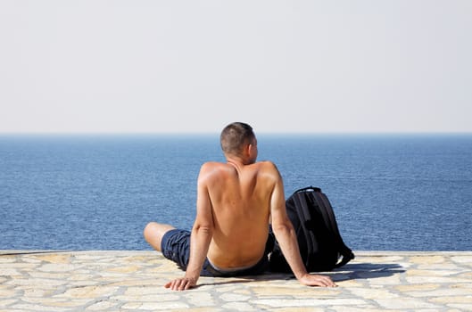 young man sitting and relaxing on coastline