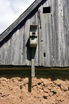 Bird house on old clay and wood farm building