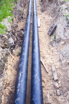 Two new black waterpipes in a ditch  