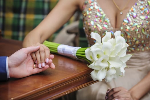 newlyweds holding hands in cafe 