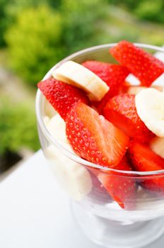 Banana and strawberry salad in a glass cup