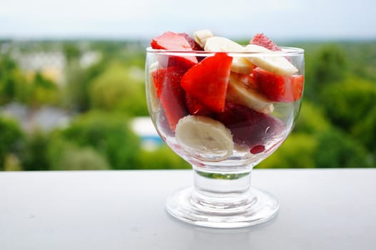 Banana and strawberry salad in a glass cup