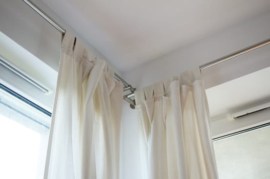 Light fabric curtains by an window