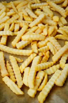 Frozen potato fries on paper