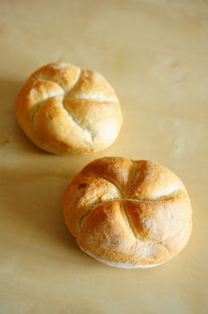 Two whole breads on wooden background