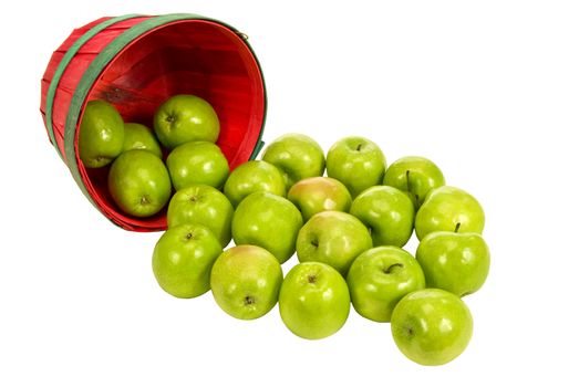 Horizontal shot of a little red basket of green apples spilling out on white background