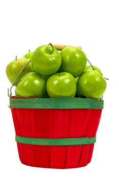 Straight on shot of a little red basket piled high with fresh picked juicy green apples on white background