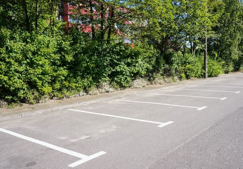 Empty parking lot with green bushes