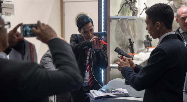 UNITED KINGDOM, London: Visitors look at pistols	The Defence and Security International Exhibition (DSEI) began in London on September 15, 2015 despite a week of direct action protests by peace campaigners.  	The arms fair has seen over 30,000 people descend on London to see the 1,500 exhibitors who are displaying weapons of war from pistols and rifles up to tanks, assault helicopters and warships.  	Protesters attempted to block the main road into the exhibition, claiming that such an event strengthened the UK's ties to human rights abuses. 