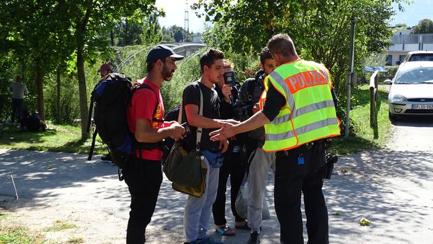 GERMANY, Freilassing: Refugees interact with German police at the gates of Freilassing, Bavaria, on the German side of the Germany-Austria border, September 16, 2015.