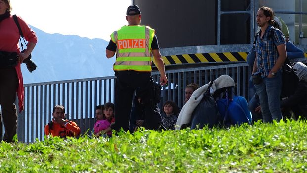 GERMANY, Freilassing: A German policeman watches over refugees at the gates of Freilassing, Bavaria, on the German side of the Germany-Austria border, September 16, 2015.
